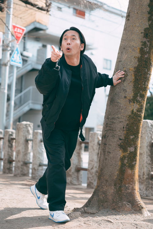 追えあいつだ！公園で鬼役の男性が指をさす