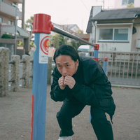 公園の鉄棒でウィービング動作の練習をするボクサーの写真
