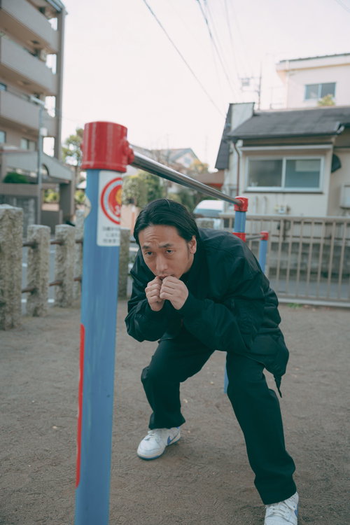 公園の鉄棒でウィービング動作の練習をするボクサー