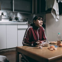 余ったお惣菜を食べるワンルーム女子の食事風景の写真