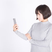 スマホを確認する女性のポートレート写真の写真