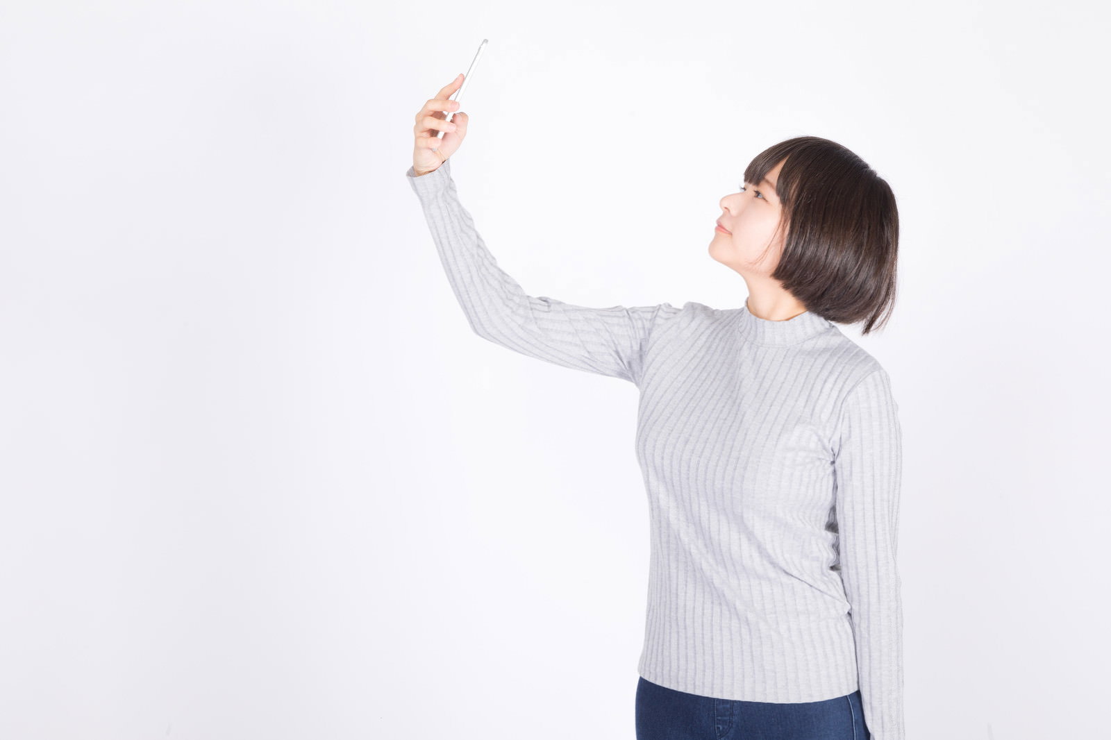 白背景で俯瞰の自撮りをしている女性［モデル：千歳］