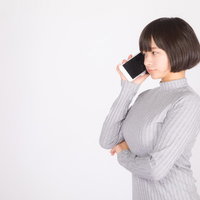スマートフォンで音声通話する若い女性の笑顔の写真