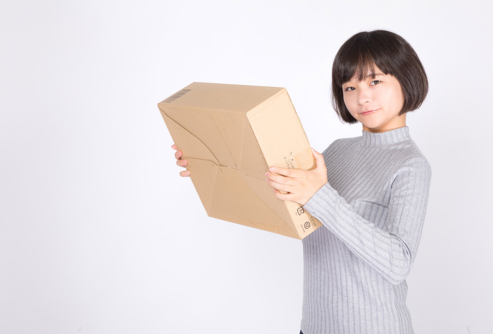 ダンボール箱を抱えてご満悦な女性［モデル：千歳］