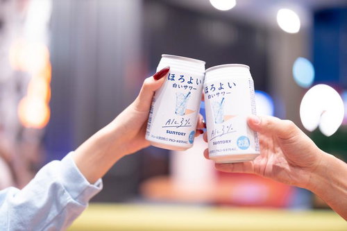 夜景の中で缶のお酒で乾杯するカップルの夜間デート