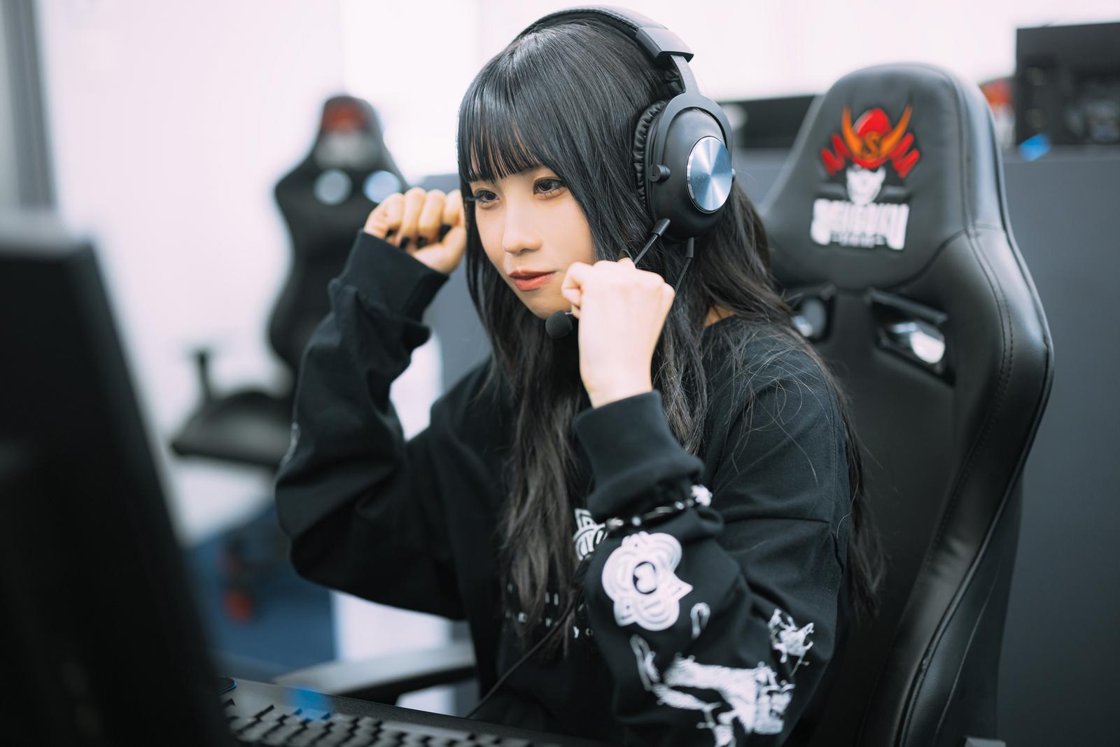 ヘッドセットを装着してガッツポーズを決める女性eスポーツゲーマー［モデル：るい］