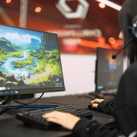 ヘッドセットをしながらeスポーツをプレイする様子の写真