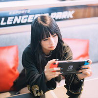 eスポーツ施設で携帯ゲームをプレイする女性の写真