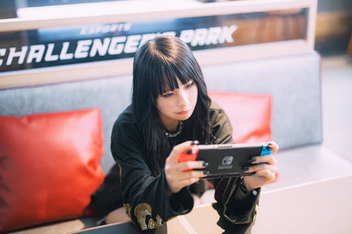eスポーツ施設で携帯ゲームをプレイする女性