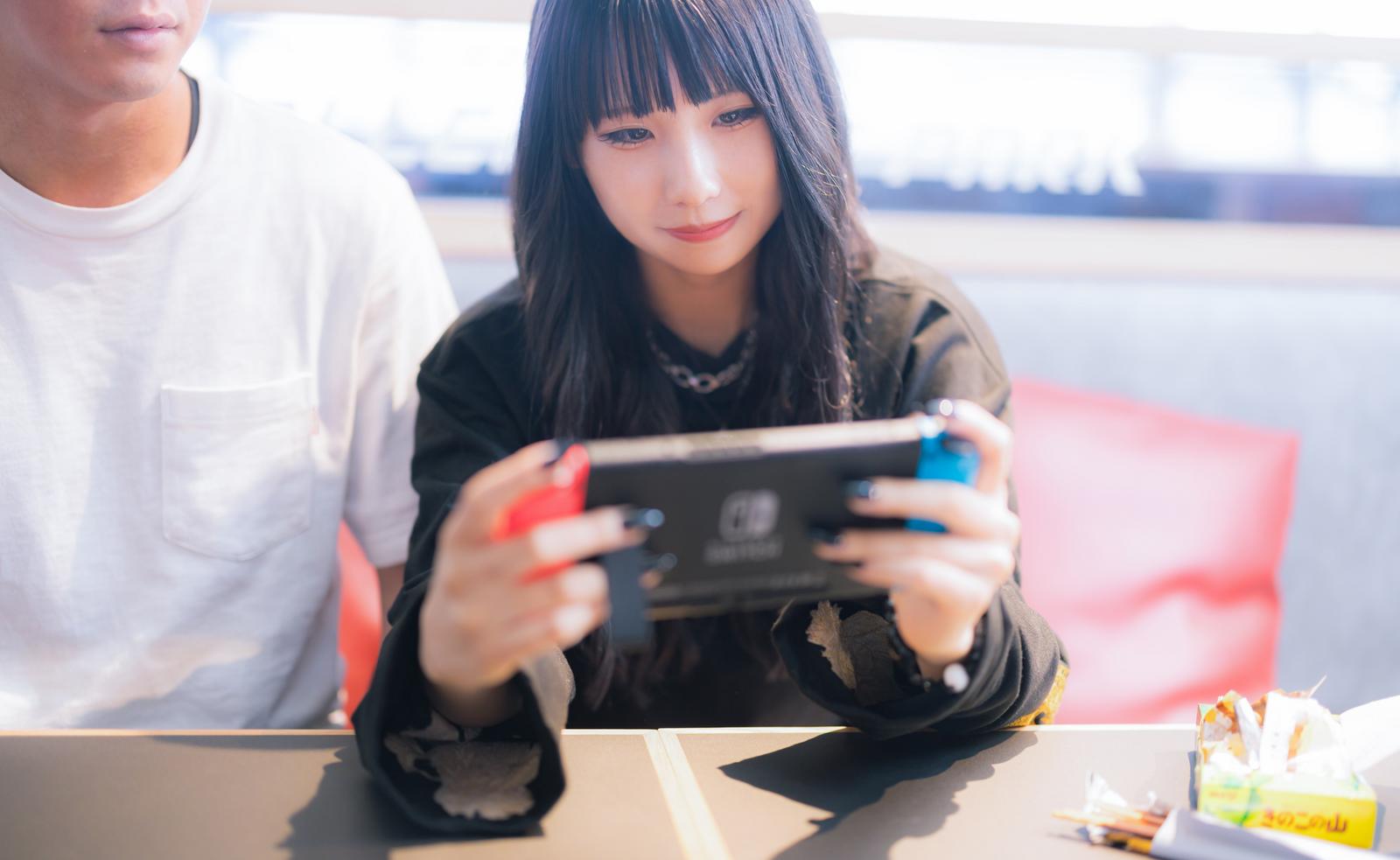 彼氏と並んでNintendo Switchをプレイする女性［モデル：るい］