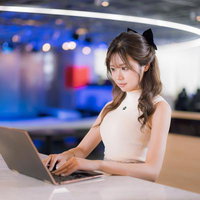 カフェエリアでリラックスしながらPC作業をする女性の写真