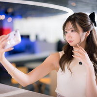 ネオン照明のモダンカフェで自撮りする女性の写真