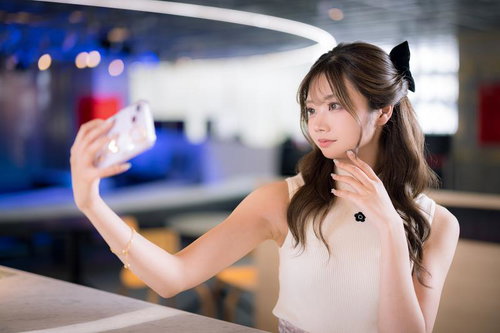 ネオン照明のモダンカフェで自撮りする女性