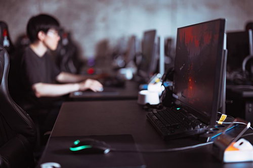 eスポーツのプレイエリアでゲーミングPCを操作するゲーマー