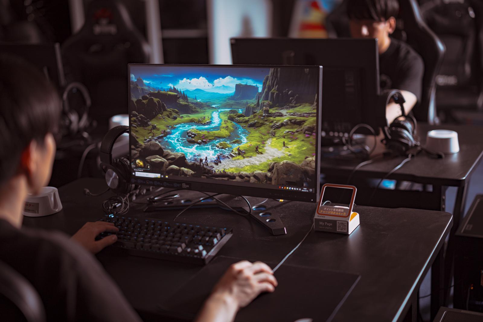 ゲーミングディスプレイにゲーム画面を映しながらゲーミングPCを操作する人物