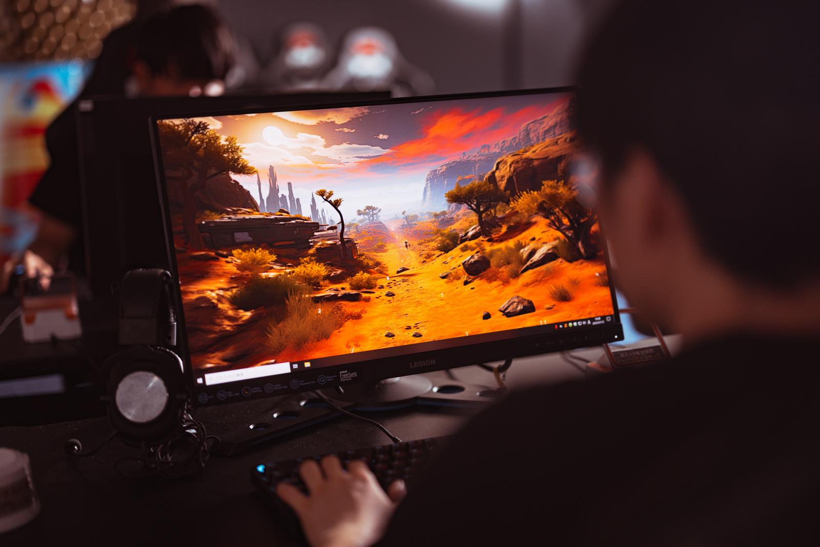 モニターに表示されたFPSゲーム画面を見ながらプレイするゲーマー