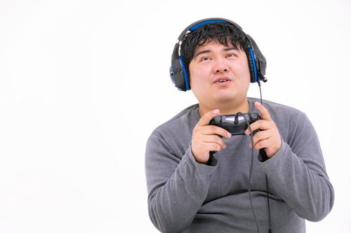 ゲームパッドを握ってPCゲームをプレイする男性