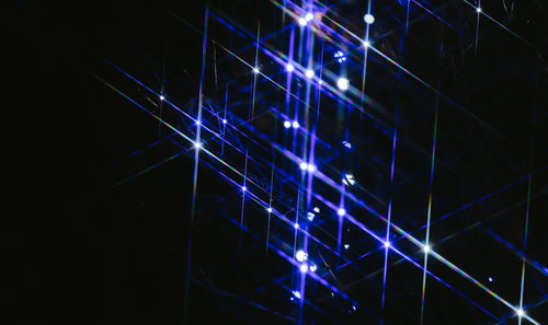 ライトアップされた青い光線が交差するキラキラ光るデジタルパターン