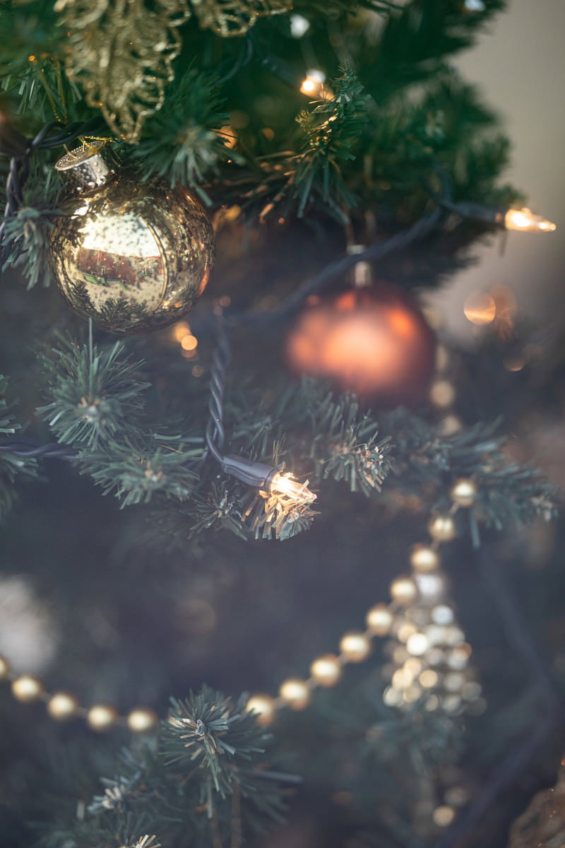 ゴールドのオーナメントと暖かいライトで飾られたクリスマスツリー