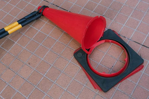 倒れて折れてしまった赤い交通コーンと台座