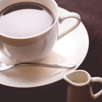 淹れたてコーヒーとミルクピッチャーのテーブルウェアの写真