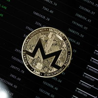 XMR（モネロ）コインとディスプレイ画面の仮想通貨チャートの写真
