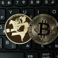黒いキーボードの上に置かれたダッシュコインとビットコインの写真