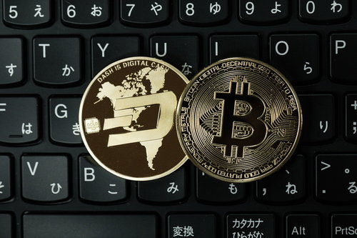黒いキーボードの上に置かれたダッシュコインとビットコイン