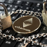 イーサリアムのロゴが刻まれた金色の南京錠とチェーンの写真