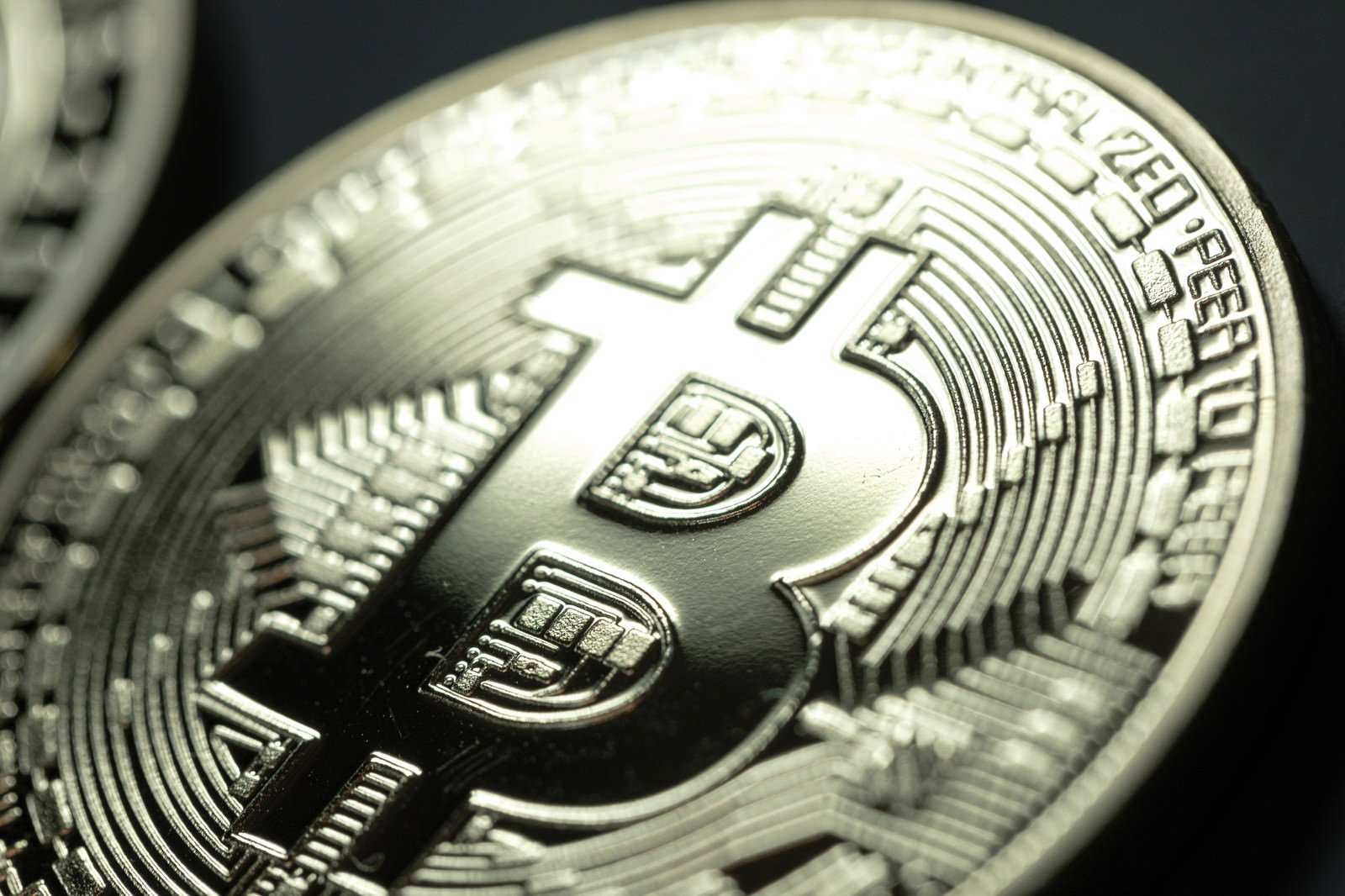 金色のメタリックな表面にビットコインロゴが刻印されたコイン