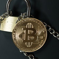 セキュリティで保護された金色のビットコインと南京錠の写真