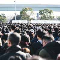 黒やグレーの服装の人たちでごった返す行列の写真