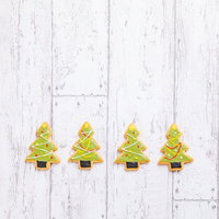 クリスマスツリー型のアイシングクッキー、緑色に仕上げた手作りお菓子の写真