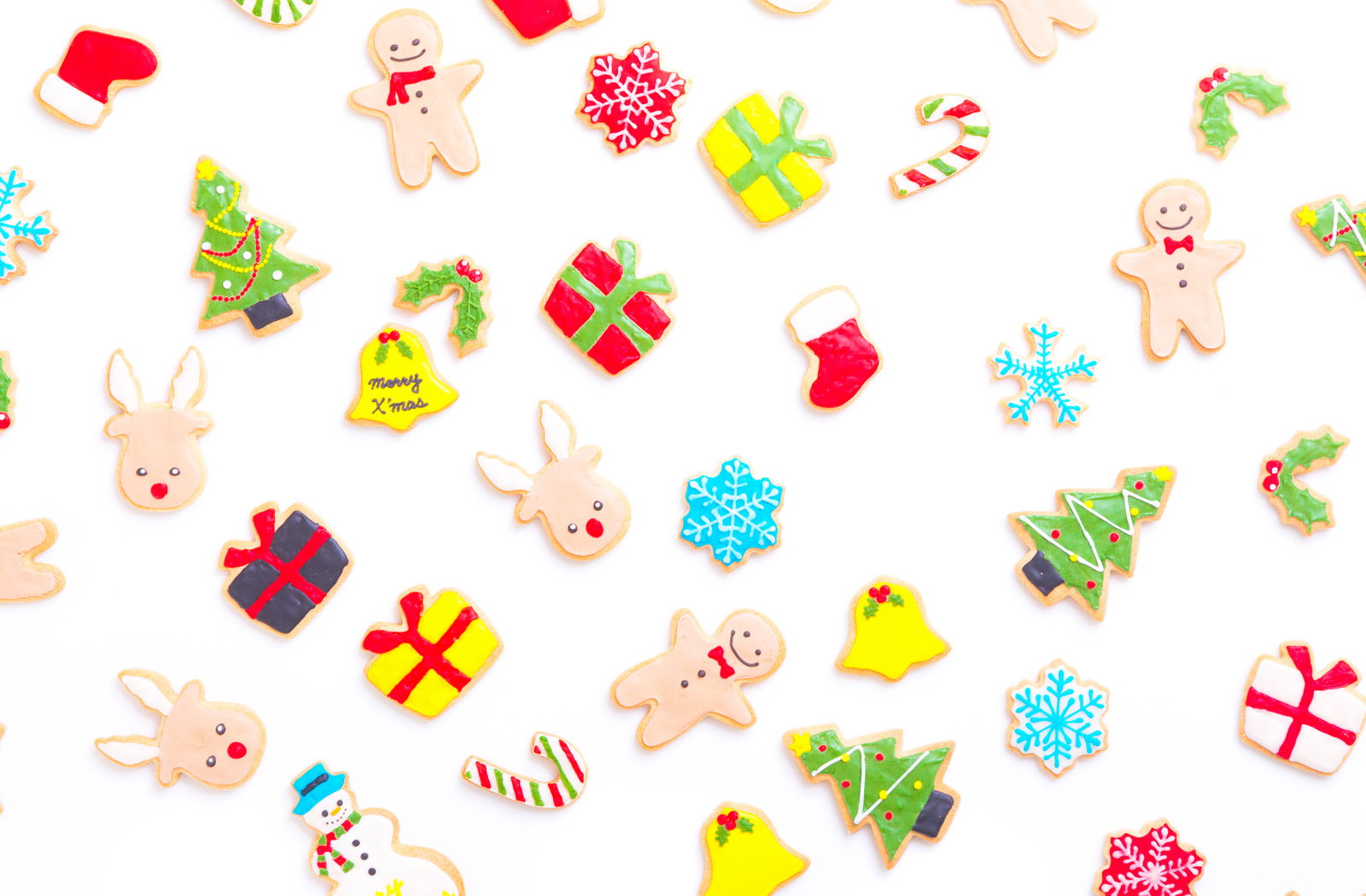 白い背景に並んだ色とりどりのクリスマスアイシングクッキー