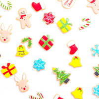 星やプレゼント、雪の結晶など多彩な形のカラフルなクリスマス用アイシングクッキーの写真