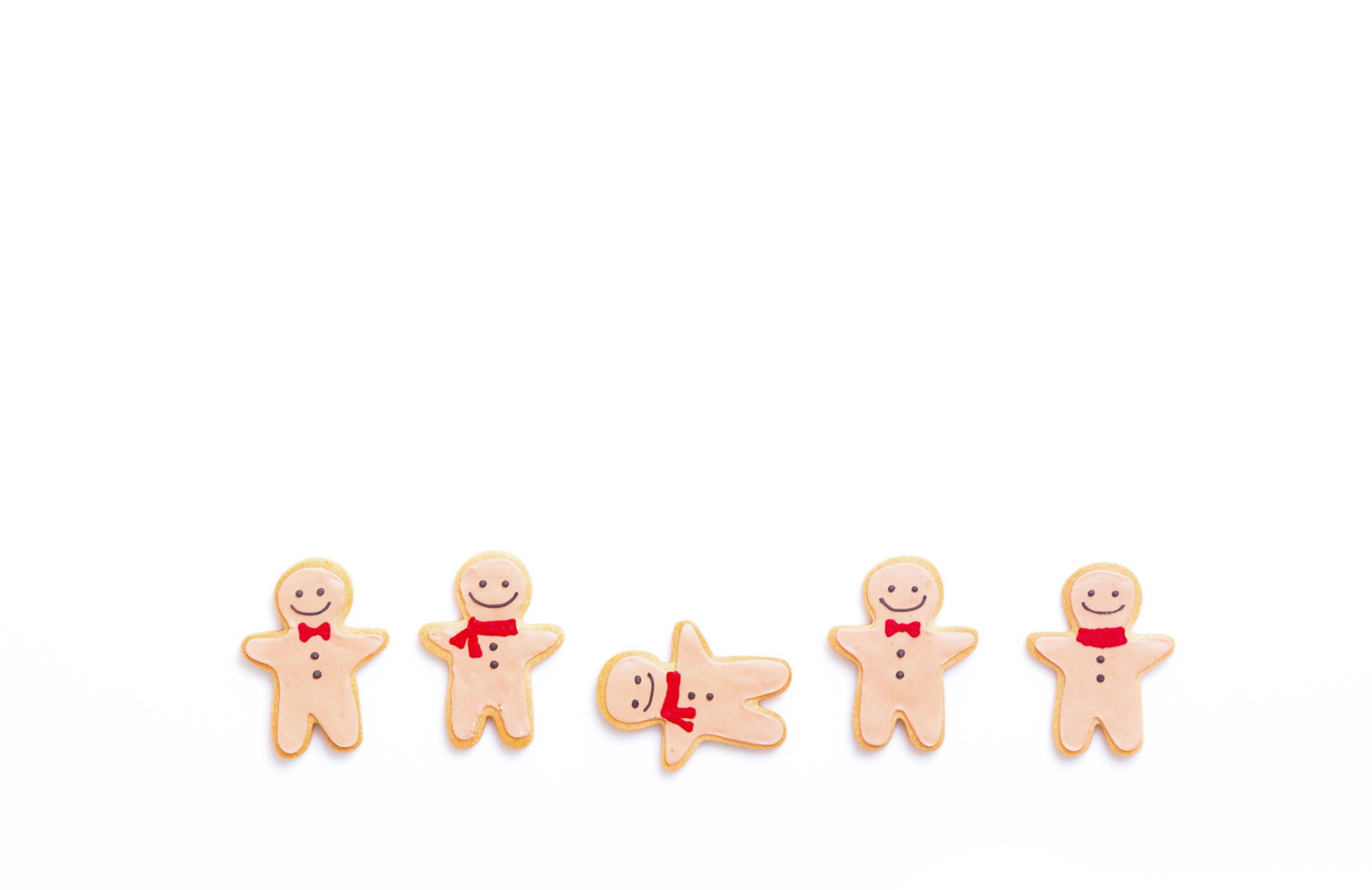 白背景に並んだ5つのアイシングクッキー、4つが笑顔で1つだけ泣き顔