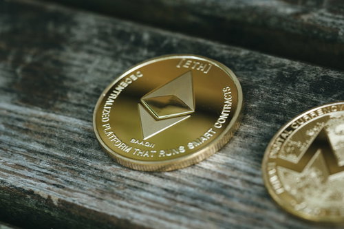 木製テーブルに置かれた輝くイーサリアムコイン