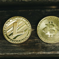 卓上に並ぶライトコインとビットコインの仮想通貨コインの写真