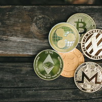 複数の暗号資産が集めた仮想通貨コイン、木製テーブルに並ぶの写真