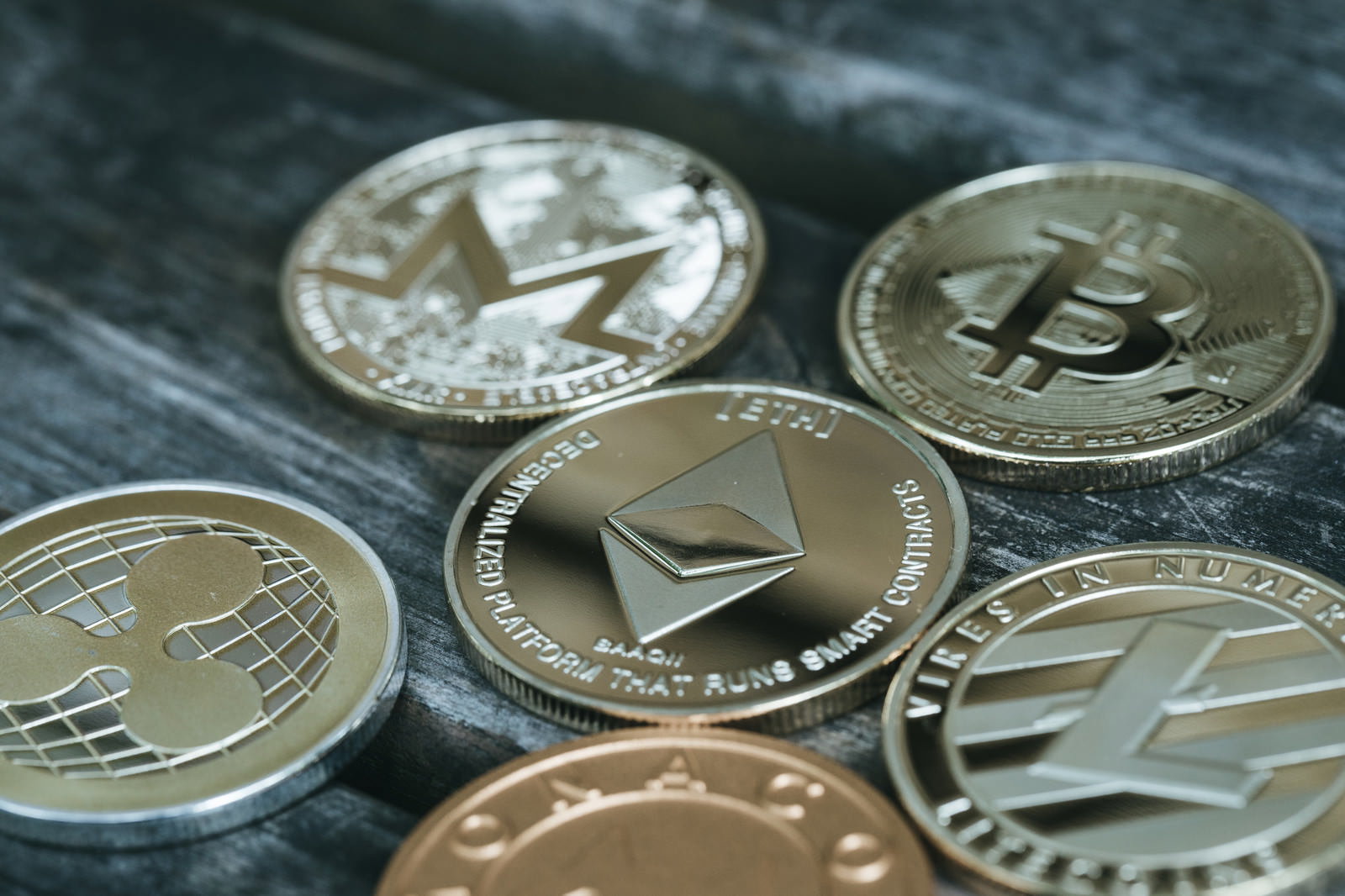 机の上に置かれた複数の仮想通貨コイン