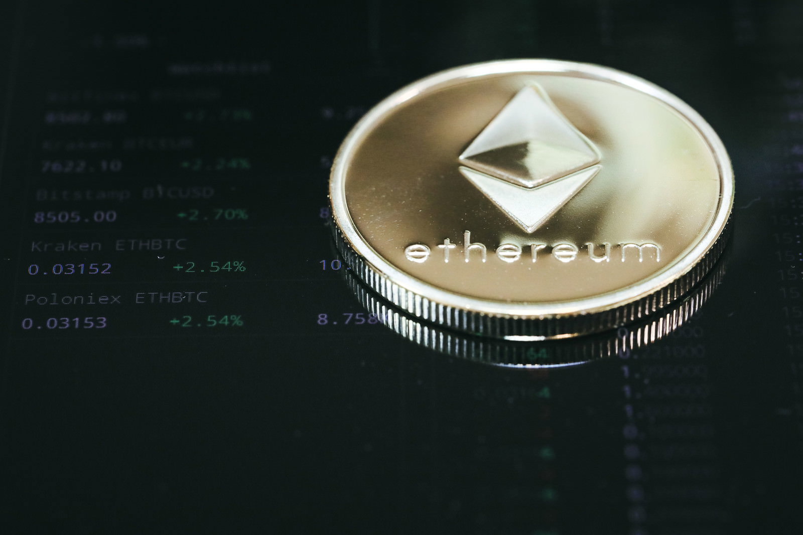黒い背景に置かれた金色のイーサリアムコイン