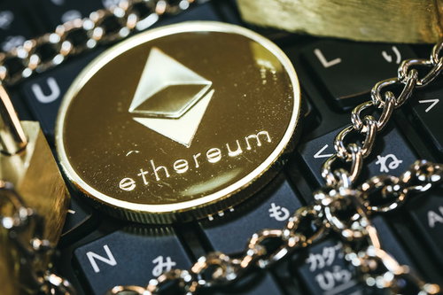 キーボード上に置いた金色のチェーンとイーサリアム（ETH）コイン