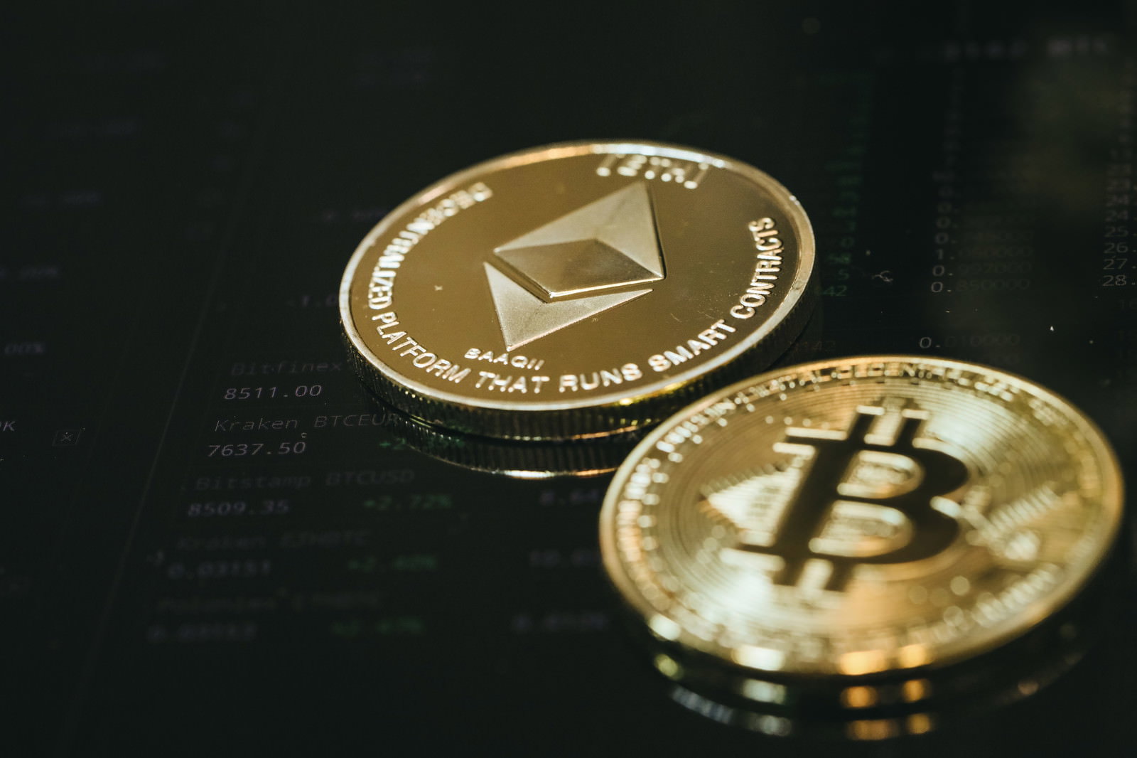 暗い背景に置かれたビットコインとイーサリアムの金色のコイン
