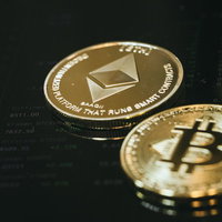取引画面上に置かれたビットコインとイーサリアムの仮想通貨の写真