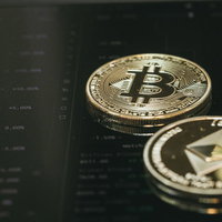 取引画面上に置かれたビットコインとイーサリアムの仮想通貨コインの写真