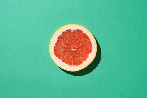 グリーンの背景紙とカットしたグレープフルーツ