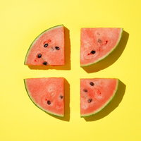 黄色の背景に並べたカットすいかのフルーツデザインの写真