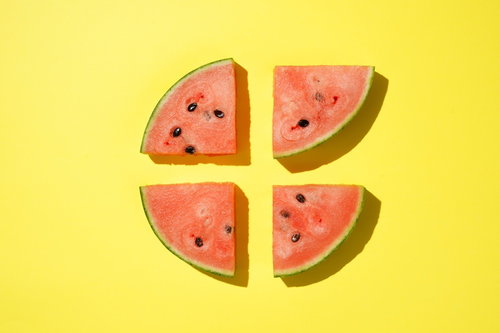黄色の背景に並べたカットすいかのフルーツデザイン