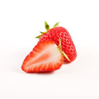 ハーフカットしたいちごの断面、赤い果肉と白い種が見えるの写真