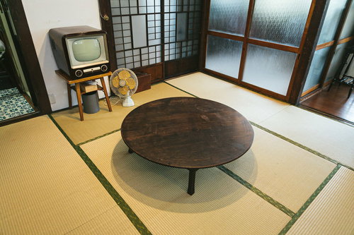 古民家の和室に置かれた丸いちゃぶ台とアナログテレビ